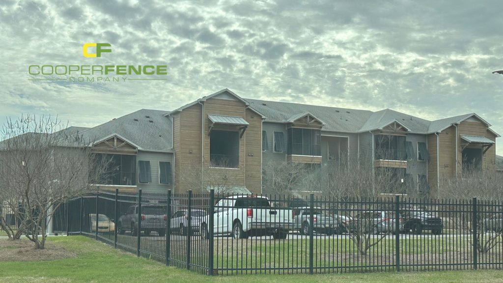 Black aluminum security fence in front of modern apartment complex installed by Cooper Fence Company in Alabama.