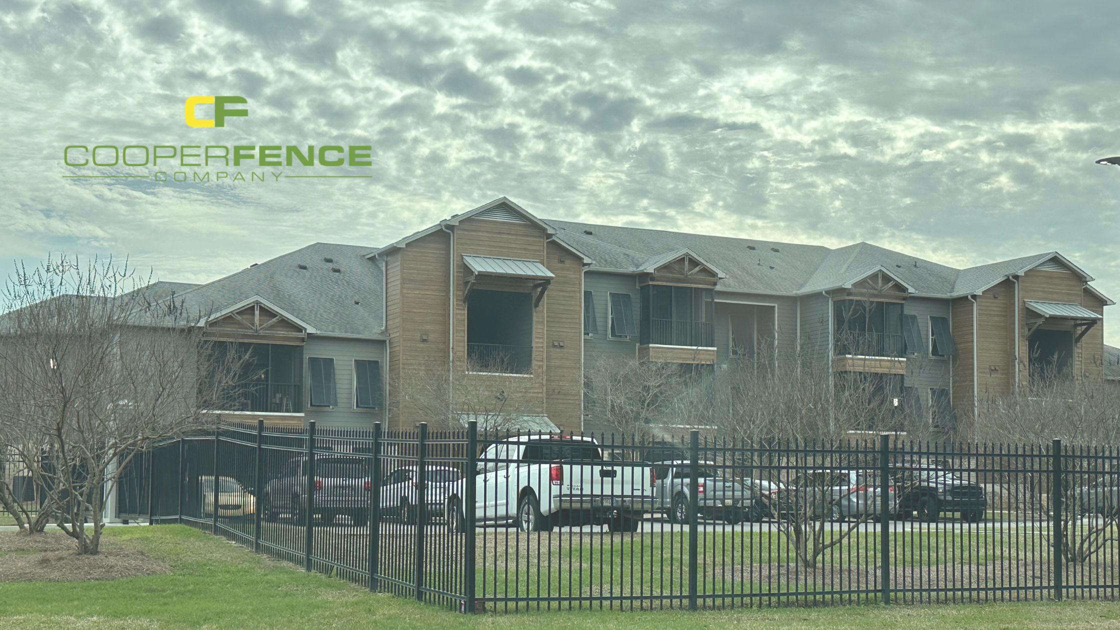 Black aluminum security fence in front of modern apartment complex installed by Cooper Fence Company in Alabama.